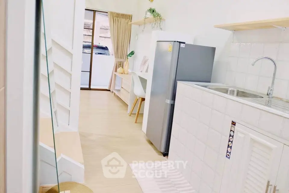 Modern compact kitchen with sleek appliances and dining area in bright apartment
