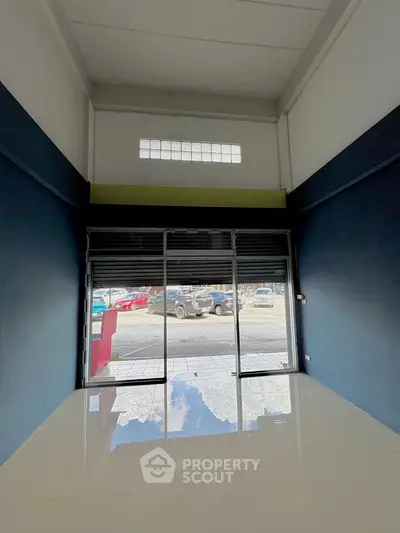 Spacious commercial space with large glass storefront and polished floors, ideal for retail or office use.