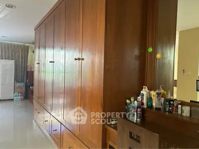 Spacious bedroom with large wooden wardrobe and ample storage space