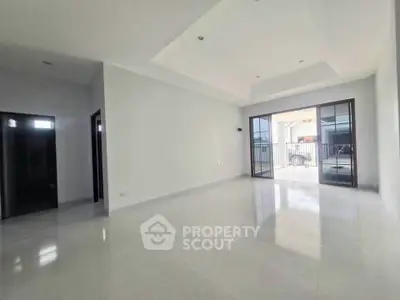 Spacious living room with large windows and glossy floors, perfect for natural light and modern living.