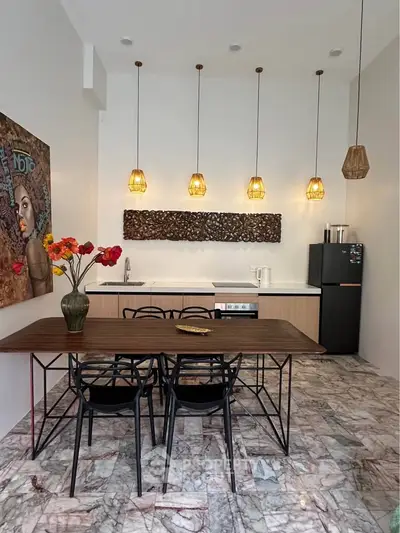 Stylish kitchen with modern dining area, pendant lighting, and artistic decor in a contemporary home.