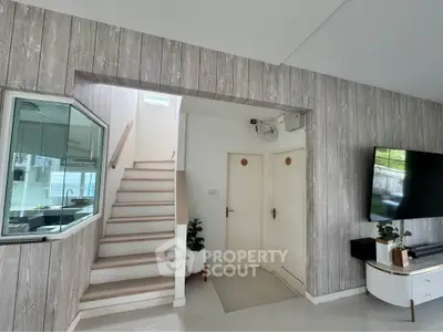 Modern living room with stylish wood paneling and staircase