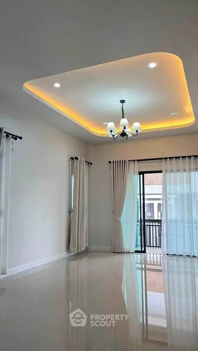 Spacious living room with elegant ceiling lights and large windows for natural light.