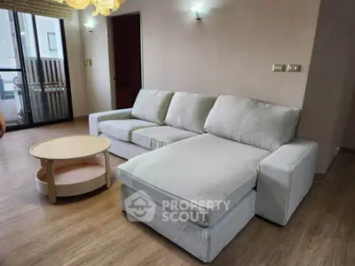 Spacious living room with modern sofa and wooden flooring, perfect for relaxation and entertaining guests.