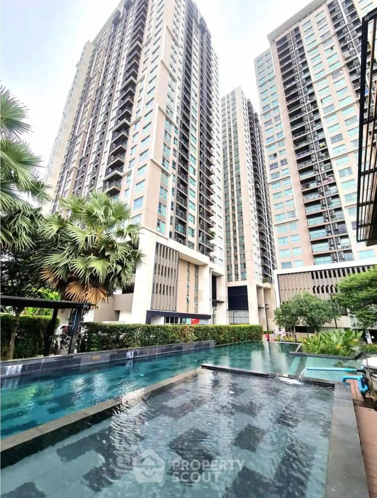 Luxurious high-rise condominium with stunning pool and lush greenery, perfect for modern urban living.