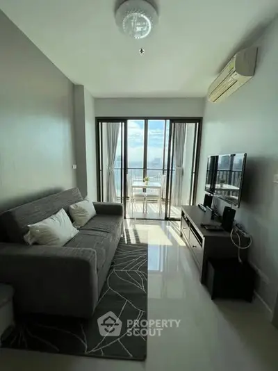 Modern living room with ocean view, featuring sleek furniture and large windows.