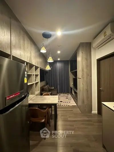 Modern living room with stylish lighting and open layout, featuring a cozy dining area and sleek wood finishes.