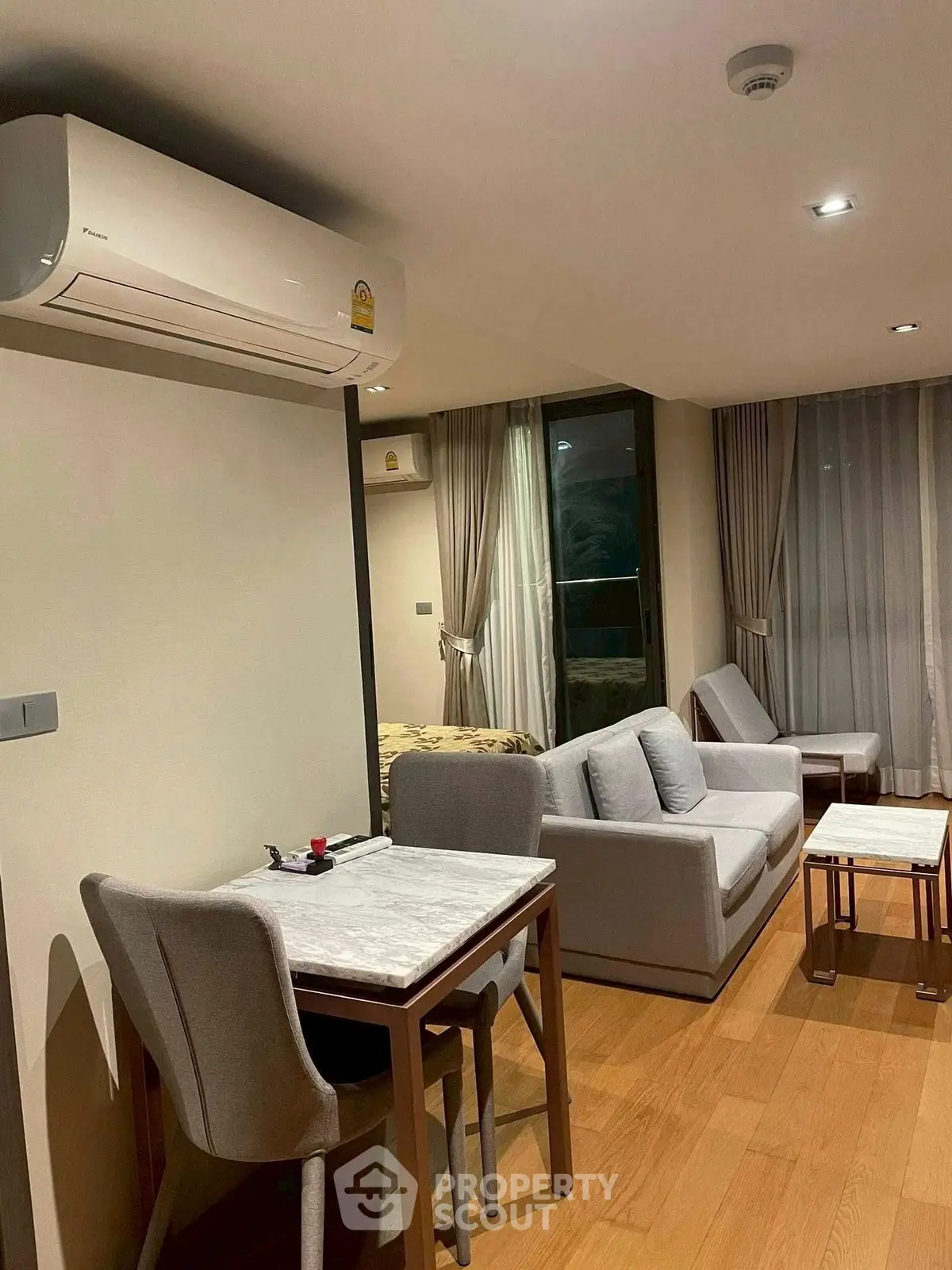 Modern living room with cozy seating and dining area, featuring elegant decor and natural lighting.