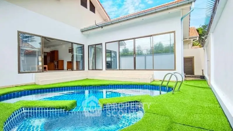 Stunning modern home with private pool and lush green lawn, perfect for relaxation and entertainment.