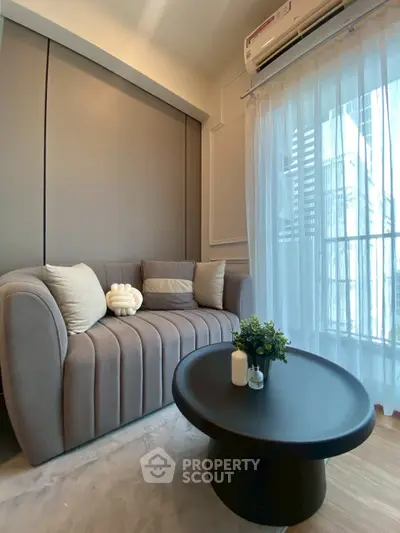 Stylish modern living room with cozy sofa and large window view