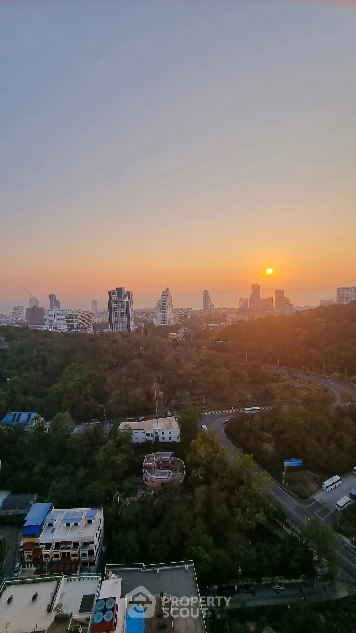 Stunning cityscape view at sunset with lush greenery and skyline
