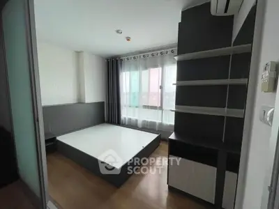 Modern bedroom with built-in shelves and large window, featuring sleek design and ample natural light.
