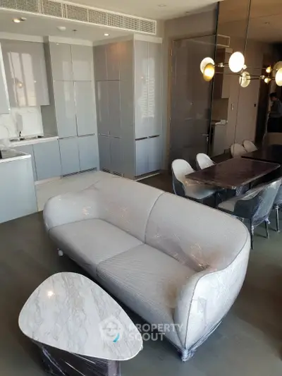 Modern living room with sleek kitchen and stylish furniture in a contemporary apartment.