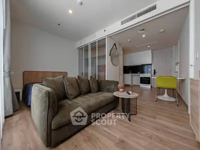 Modern open-plan living room with stylish kitchen and cozy seating area, perfect for urban living.