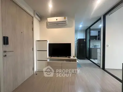 Modern apartment interior with sleek kitchen and cozy living area featuring air conditioning and stylish decor.