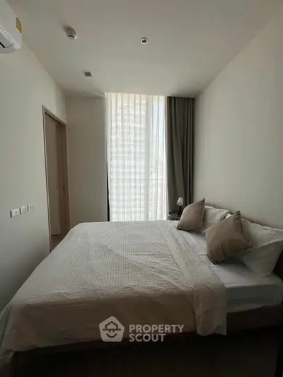 Modern bedroom with natural light and minimalist decor in a stylish apartment.