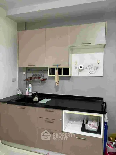 Modern kitchen with sleek cabinets and black countertop, featuring a minimalist design.