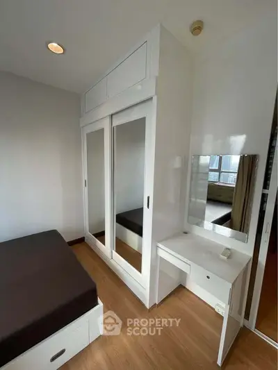Modern bedroom with mirrored wardrobe and vanity in a bright apartment