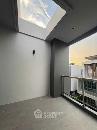 Modern balcony with skylight and glass railing offering serene views.