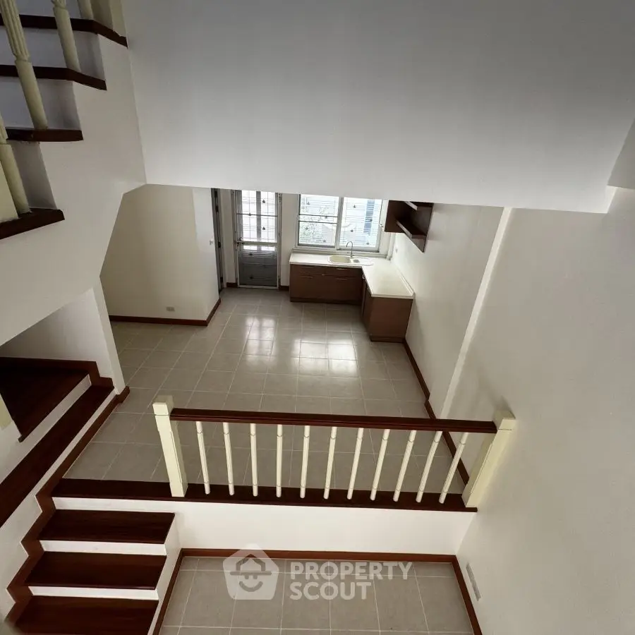 Spacious multi-level interior with modern staircase and large windows.