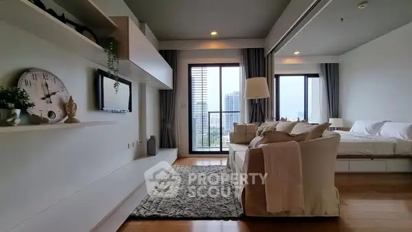 Modern living room with large windows and cozy decor in a high-rise apartment.