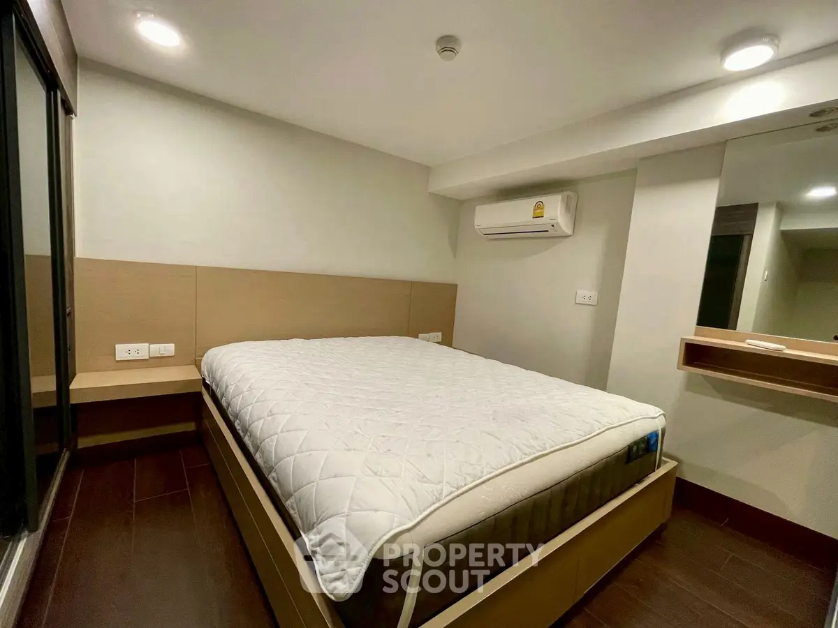 Modern bedroom with cozy bed and built-in air conditioning unit