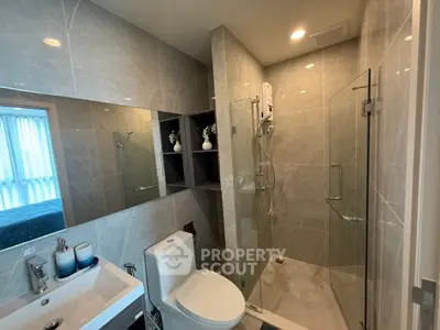 Modern bathroom with glass shower and elegant fixtures in luxury apartment