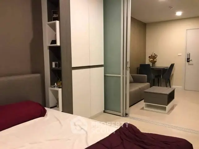 Modern bedroom with sliding doors leading to a cozy living area