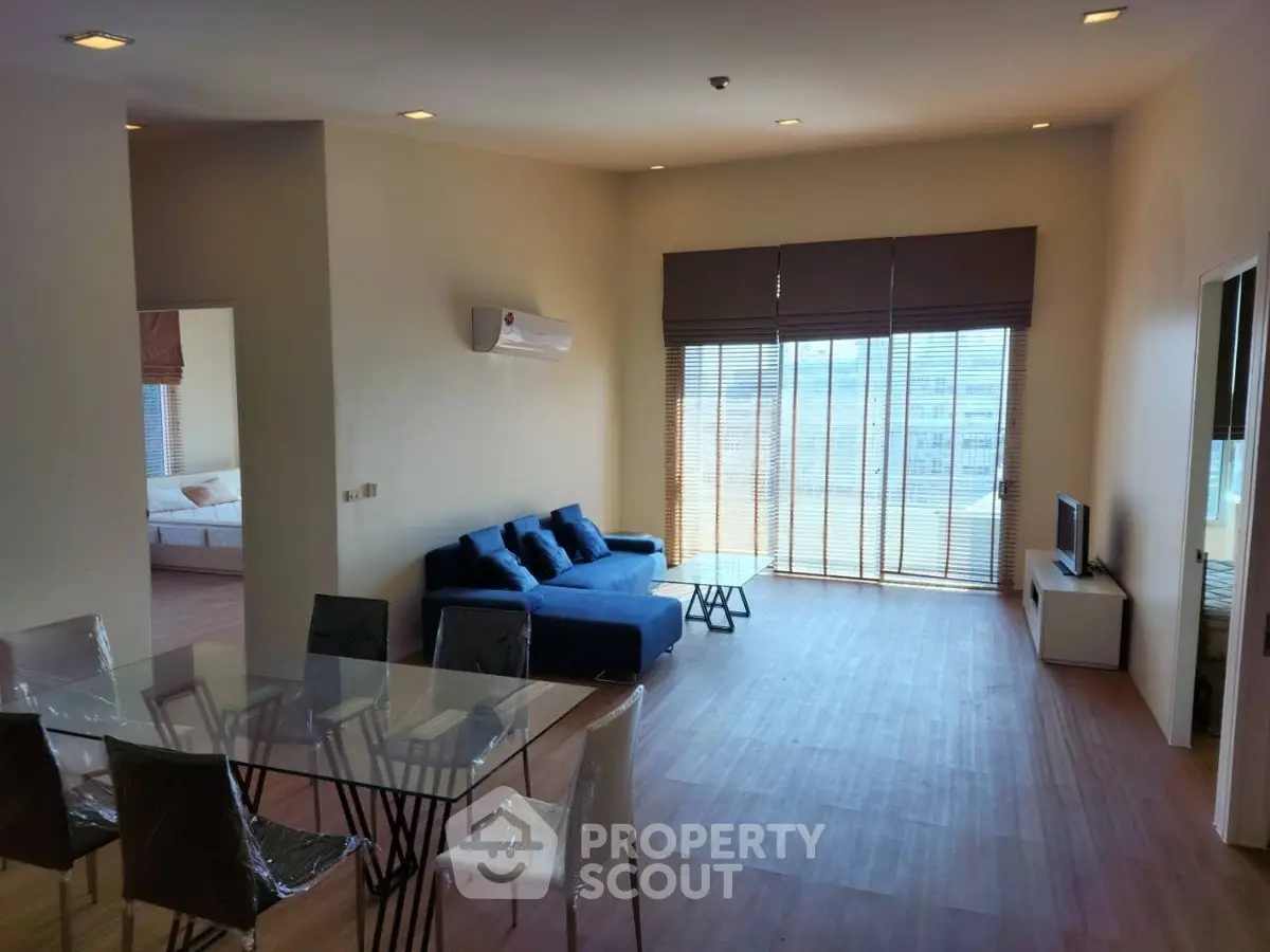 Spacious modern living room with large windows and stylish furniture in a contemporary apartment.