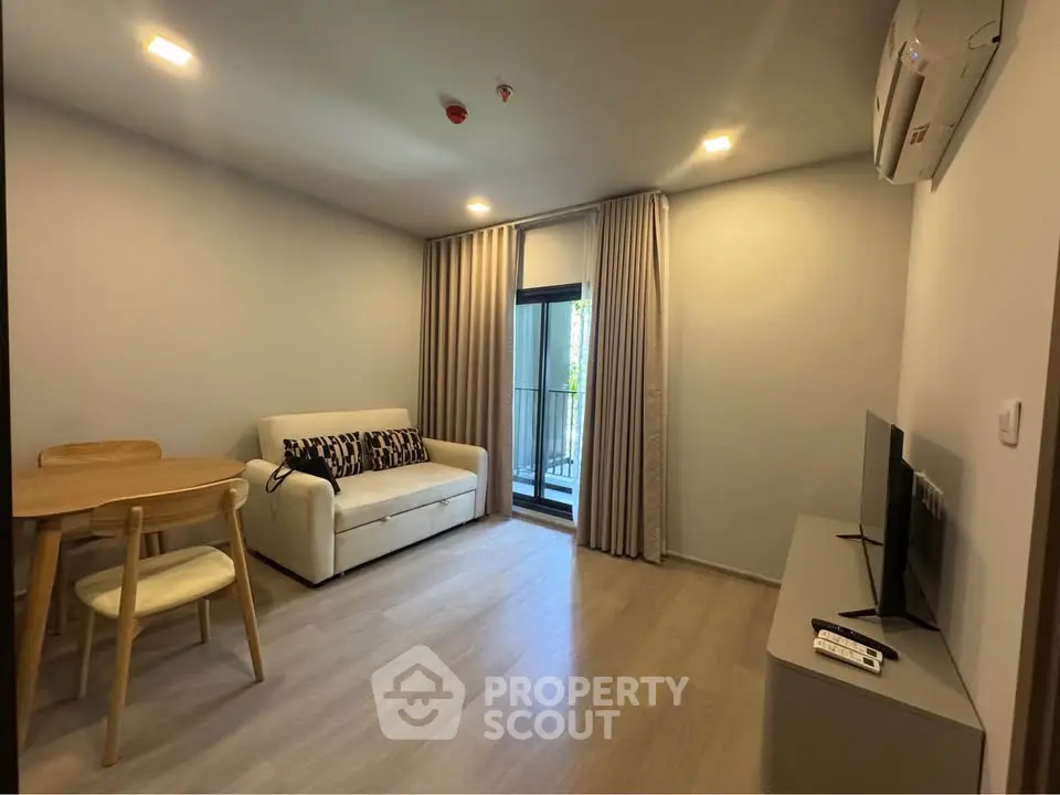 Modern living room with cozy sofa, TV, and dining area in a stylish apartment.