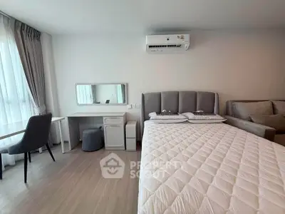 Modern bedroom with stylish decor, featuring a comfortable bed, sleek desk, and cozy seating area.