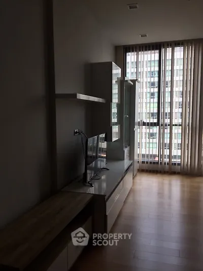 Modern living room with sleek furniture and large windows offering city view