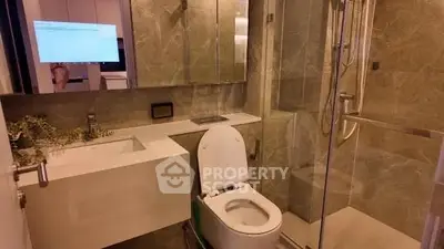 Modern bathroom with sleek fixtures and glass shower enclosure.