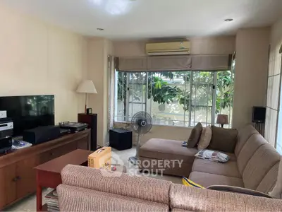 Cozy living room with large windows and comfortable seating, perfect for relaxation and entertainment.