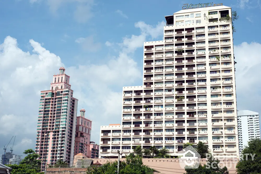 Majestic high-rise residential towers against a blue sky, offering luxurious living with a blend of modern architecture and lush green surroundings.