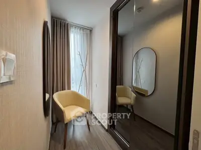 Cozy modern hallway with elegant chair and mirror, perfect for stylish living.