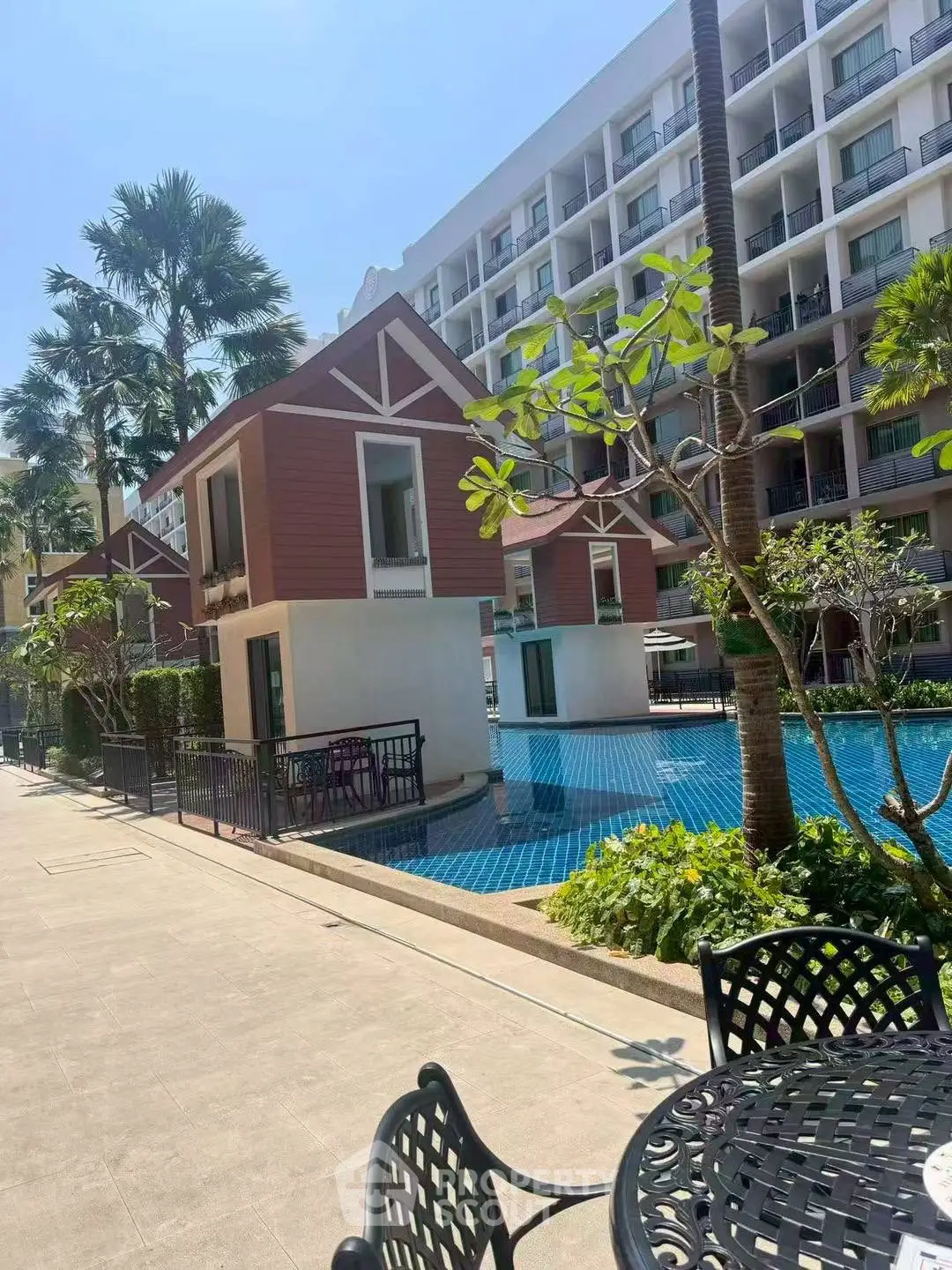 Luxurious poolside view with modern apartment complex and lush greenery
