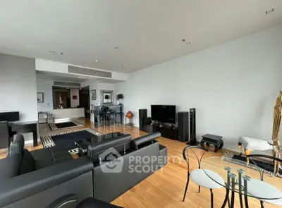 Spacious modern living room with sleek black furniture and hardwood floors