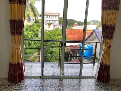 Charming balcony view with sliding glass doors and colorful curtains