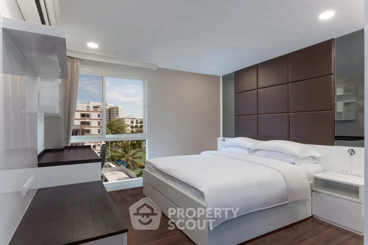 Modern bedroom with large window and stylish decor in urban apartment