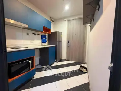 Modern kitchen with blue cabinets and sleek appliances in a stylish apartment.