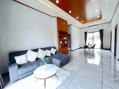 Spacious modern living room with elegant decor and dining area, featuring sleek tile flooring.