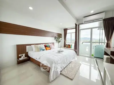 Spacious modern bedroom with large windows and stunning view, featuring elegant decor and natural light.