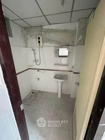 Compact bathroom with shower and pedestal sink, ideal for small spaces.
