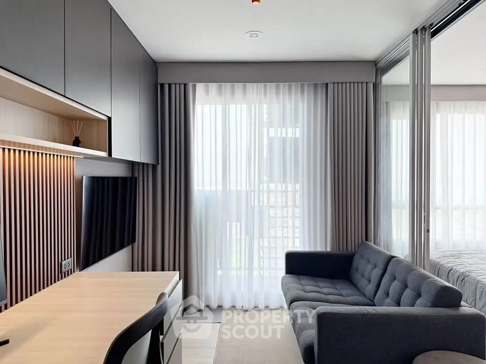 Modern living room with sleek furniture and large window, perfect for urban living.