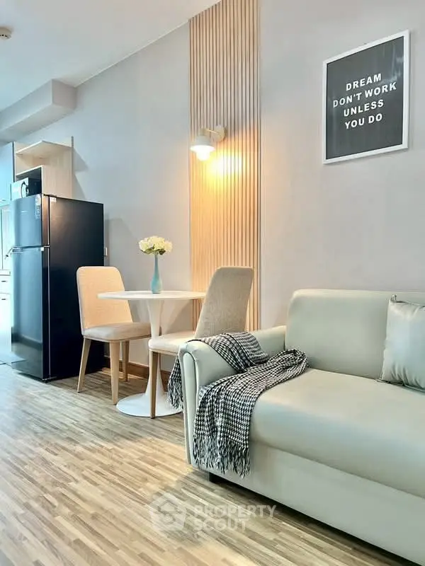 Modern living room with stylish decor, cozy sofa, dining area, and sleek kitchen appliances.