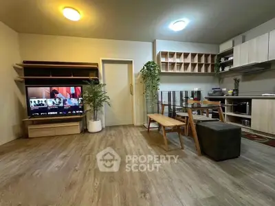 Modern open-layout living room with stylish furniture and integrated kitchen area, perfect for contemporary living.