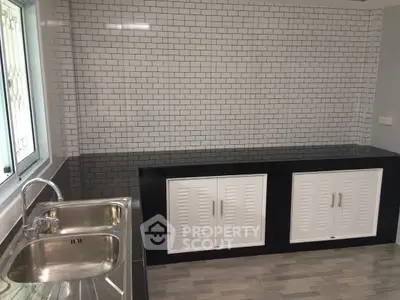 Modern kitchen with sleek tile backsplash and stainless steel sink