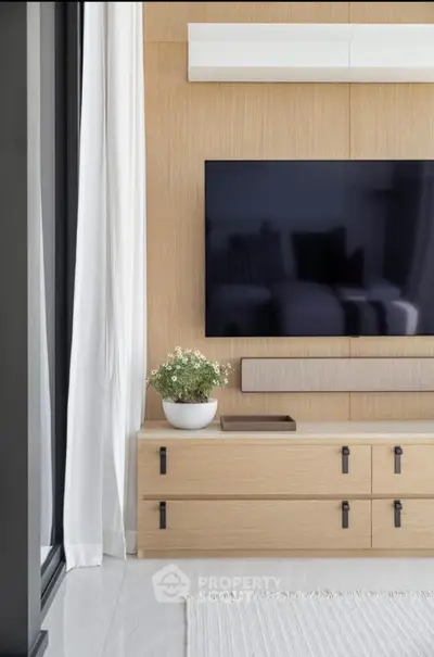 Modern living room with sleek TV setup and elegant wooden cabinetry