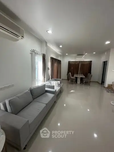 Spacious modern living room with elegant furniture and ample natural light.